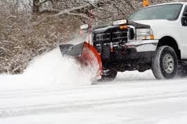truck plowing snow from road